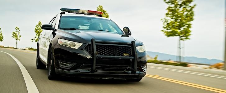 Police car driving on a winding road.