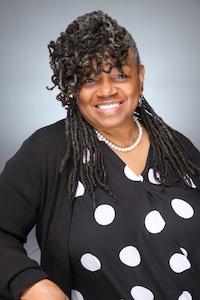 Woman in black and white polka dot shirt and black sweater