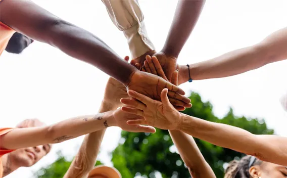 Diverse group of hands overlaid each other as show of solidarity 